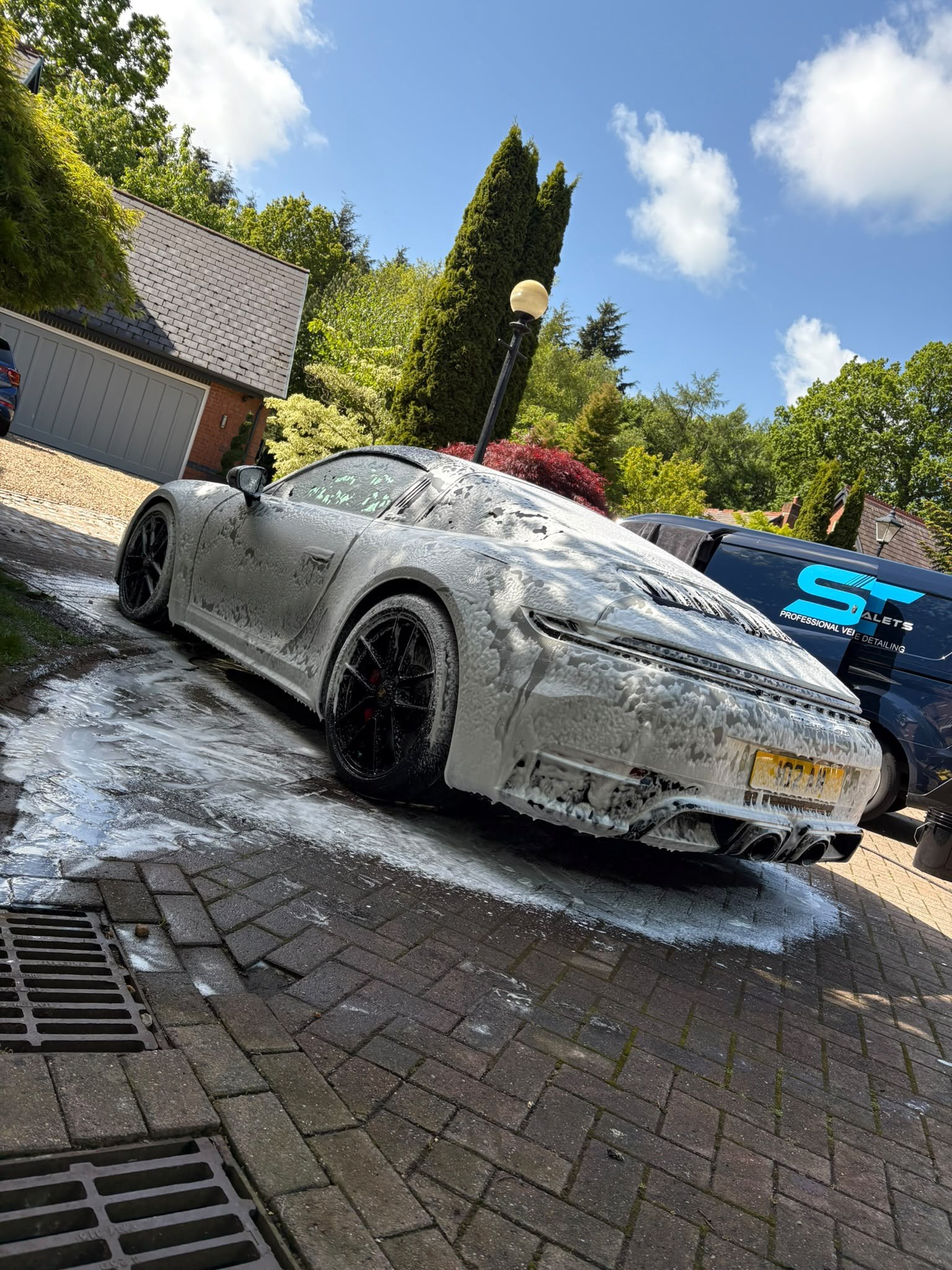 Porsche 911 covered in snow foam on a driveway during a full valet by ST Valets