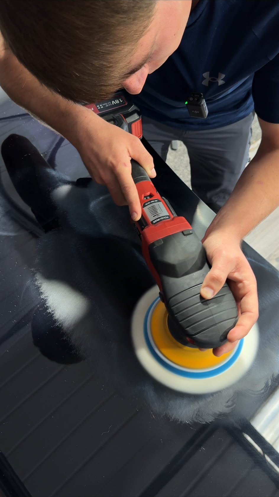 ST Valets detailer machine polishing a black panel with a Flex rotary polisher