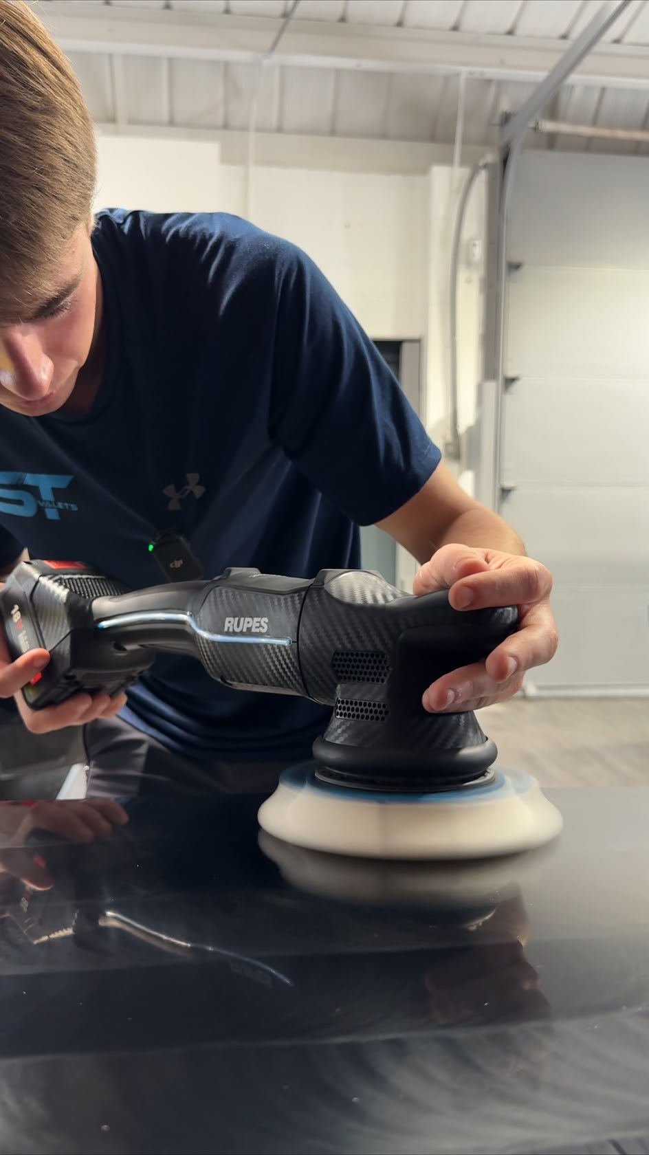 ST Valets detailer machine polishing a black car with a RUPES dual action polisher